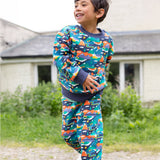 A child wearing the Frugi Malpas Joggers - Navy Alpine Adventures, and matching jumper