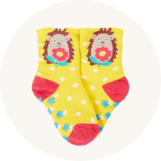 Frugi Grippy Socks in yellow with white dots with hedgehog on the angle and pink heels, made from organic cotton, to represent Frugi socks at Babipur.