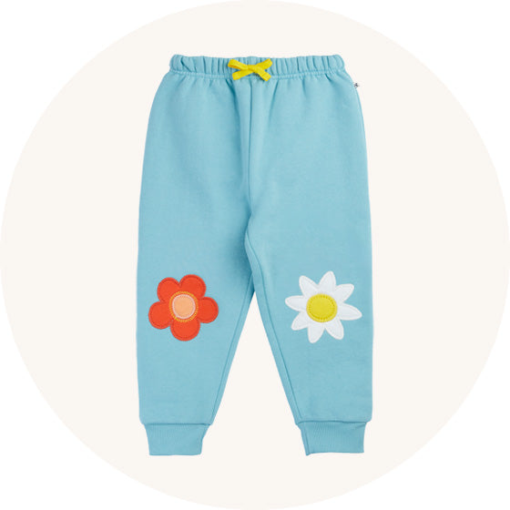 Frugi Character Joggers in Lichen blue with flower applique on knees, made from organic cotton, to represent Frugi bottoms and trousers at Babipur.