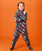 Frugi big organic cotton snuggle suit in blue with rainbow rocket and planet design, worn by child with hood up.