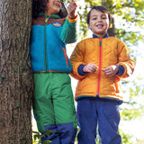 A child wearing the Frugi kids braken fleece cord jacket in holly green/hotchpotch and standing next to a child wearing the Frugi robin reversible quilted jacket - gold / blue