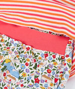 Frugi's baby all in one outfit laid flat showing close up of the pink elasticated waist band on the floral bottoms