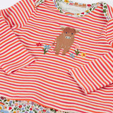 Frugi's baby all in one outfit laid flat showing close up of the cute highland cow applique on organic cotton fabric. Features a envelope neckline