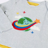 Frugi's baby all in one outfit laid flat showing close up of the cute planet earth applique on organic cotton fabric. Features a envelope neckline