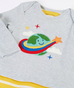 Frugi's baby all in one outfit laid flat showing close up of the cute planet earth applique on organic cotton fabric. Features a envelope neckline