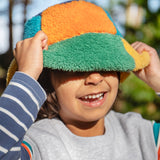 A child standing outside and wearing the Frugi kids fleece bucket hat in hotchpotch and showing the ted fleece detail available at Babipur.