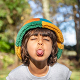 A child standing outside and wearing the Frugi kids fleece bucket hat in hotchpotch available at Babipur.
