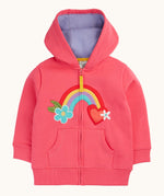 Frugi organic cotton zipped  hoodie laid flat. In light pink and a purple inner lining. Has a rainbow patch in the middle with a blue flower on one end and red heart on the other. 