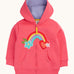Frugi organic cotton zipped  hoodie laid flat. In light pink and a purple inner lining. Has a rainbow patch in the middle with a blue flower on one end and red heart on the other. 