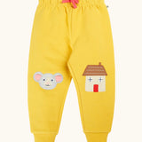 Frugi GOTS 100% organic cotton joggers in yellow with a cute mouse and house appliques on the knees. Features an elasticated wait band and pink drawcord