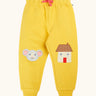 Frugi GOTS 100% organic cotton joggers in yellow with a cute mouse and house appliques on the knees. Features an elasticated wait band and pink drawcord