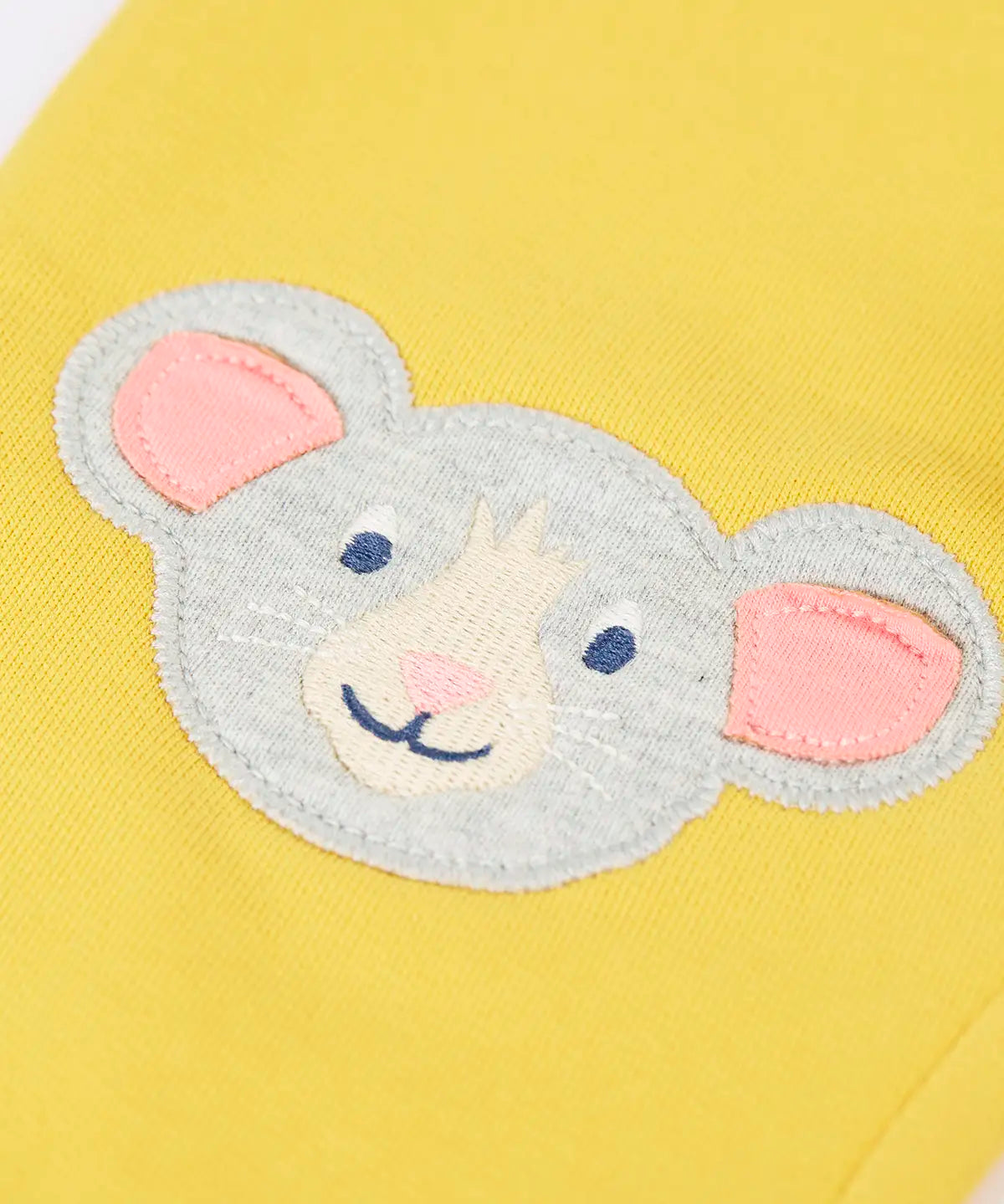 Frugi GOTS 100% organic cotton joggers in yellow showing a close up of the  cute mouse applique on the knee