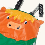 Frugi holly/green cow character puddle buster trousers laid flat showing a close up of the elasticated shoulder straps and highland cow panel