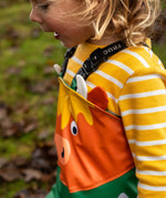 Side of child wearing the Frugi waterproof holly green/cow character puddle buster in the forest showing a close up of the Highland cow panel