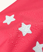 Frugi rhubarb/cat character puddle buster trousers showing water beading near the star reflective patches on the leg