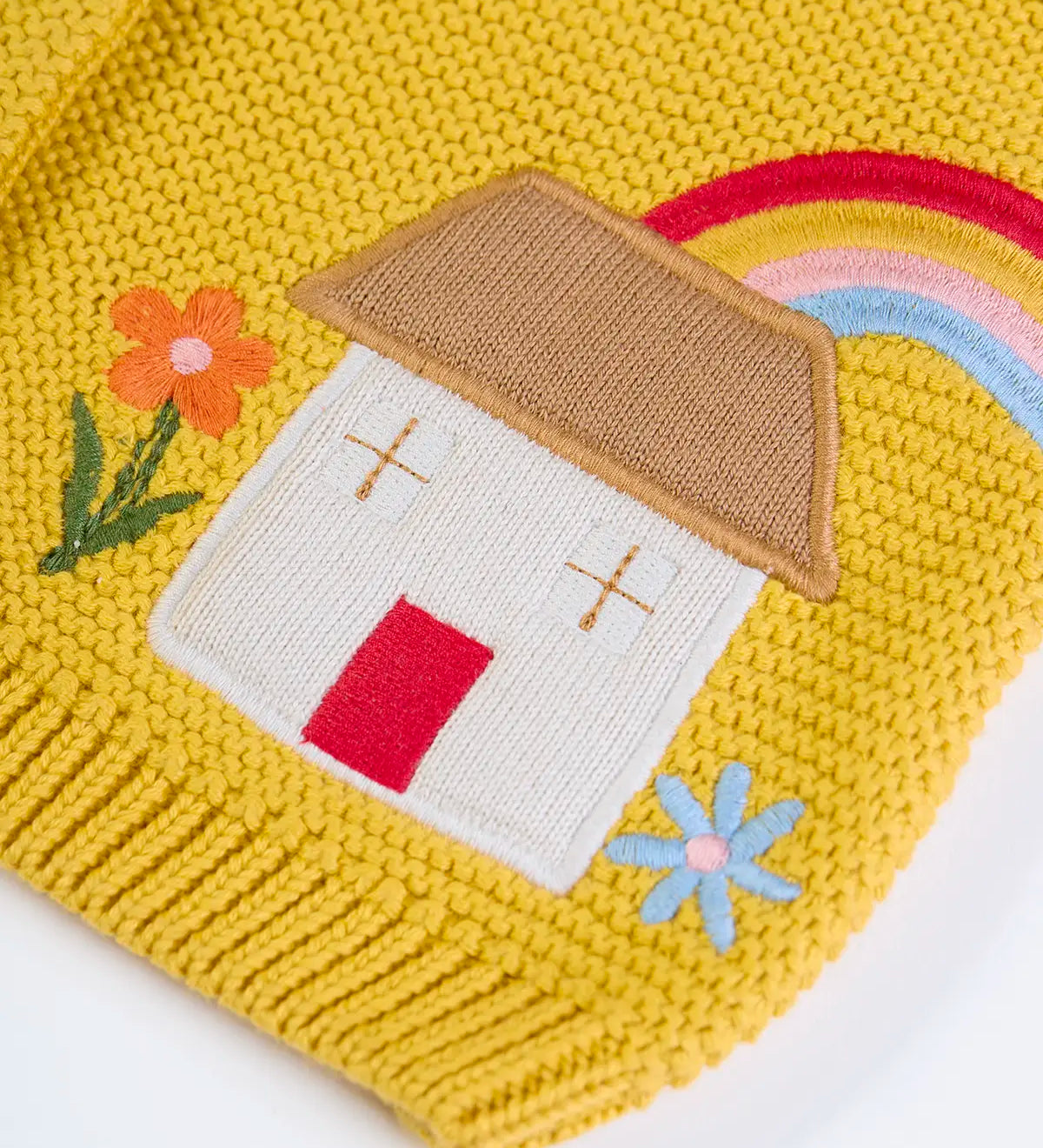 Frugi kids knitted cardigan in yellow laid flat showing a close up of the cute house applique and flower embroidery on organic cotton fabric