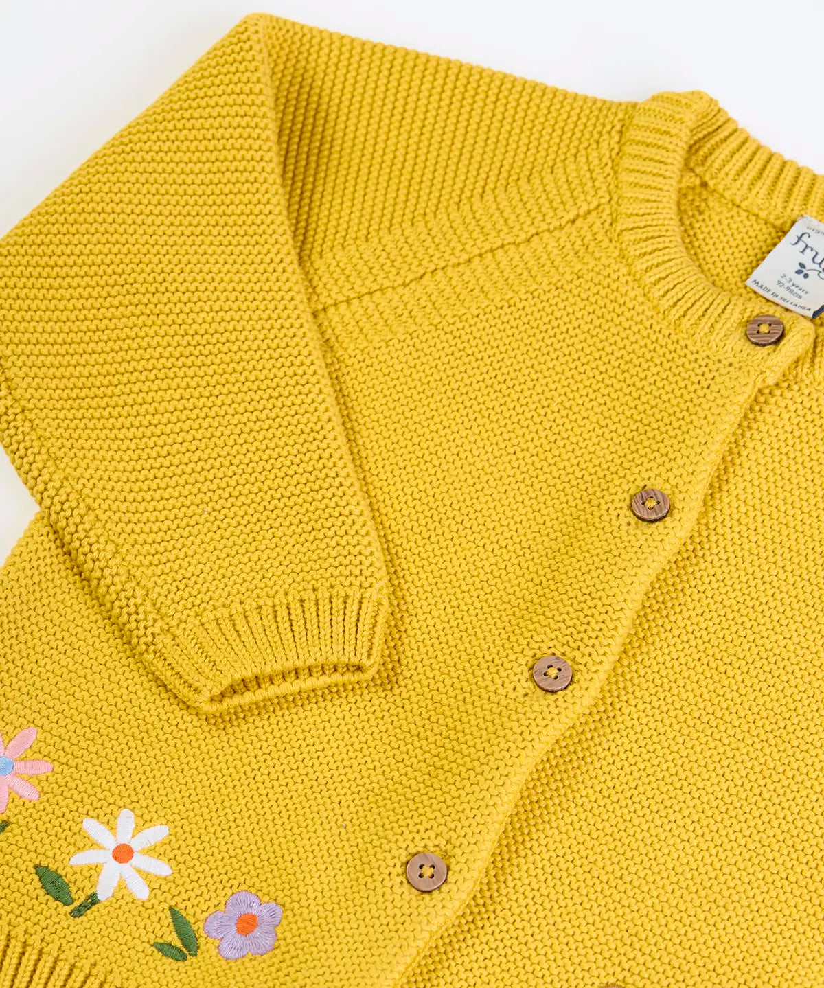Frugi kids knitted cardigan in yellow laid flat showing a close up of the wooden buttons fasteners on the front