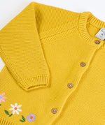 Frugi kids knitted cardigan in yellow laid flat showing a close up of the wooden buttons fasteners on the front