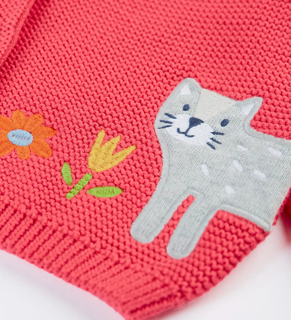 Frugi kids knitted cardigan in soft pink laid flat showing a close up of the cute cat applique on organic cotton fabric