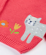 Frugi kids knitted cardigan in soft pink laid flat showing a close up of the cute cat applique on organic cotton fabric
