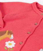 Frugi kids knitted cardigan in soft pink laid flat showing a close up of the wooden buttons fasteners on the front