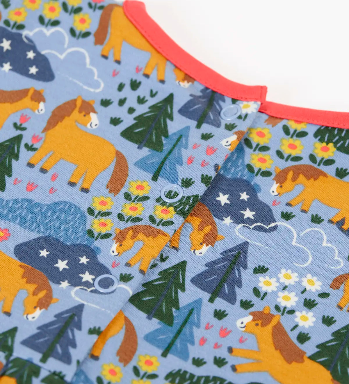 Frugi kids dress in light blue with a playful repeating shetland horse print laid flat showing popper fasteners on the back for easier dressing