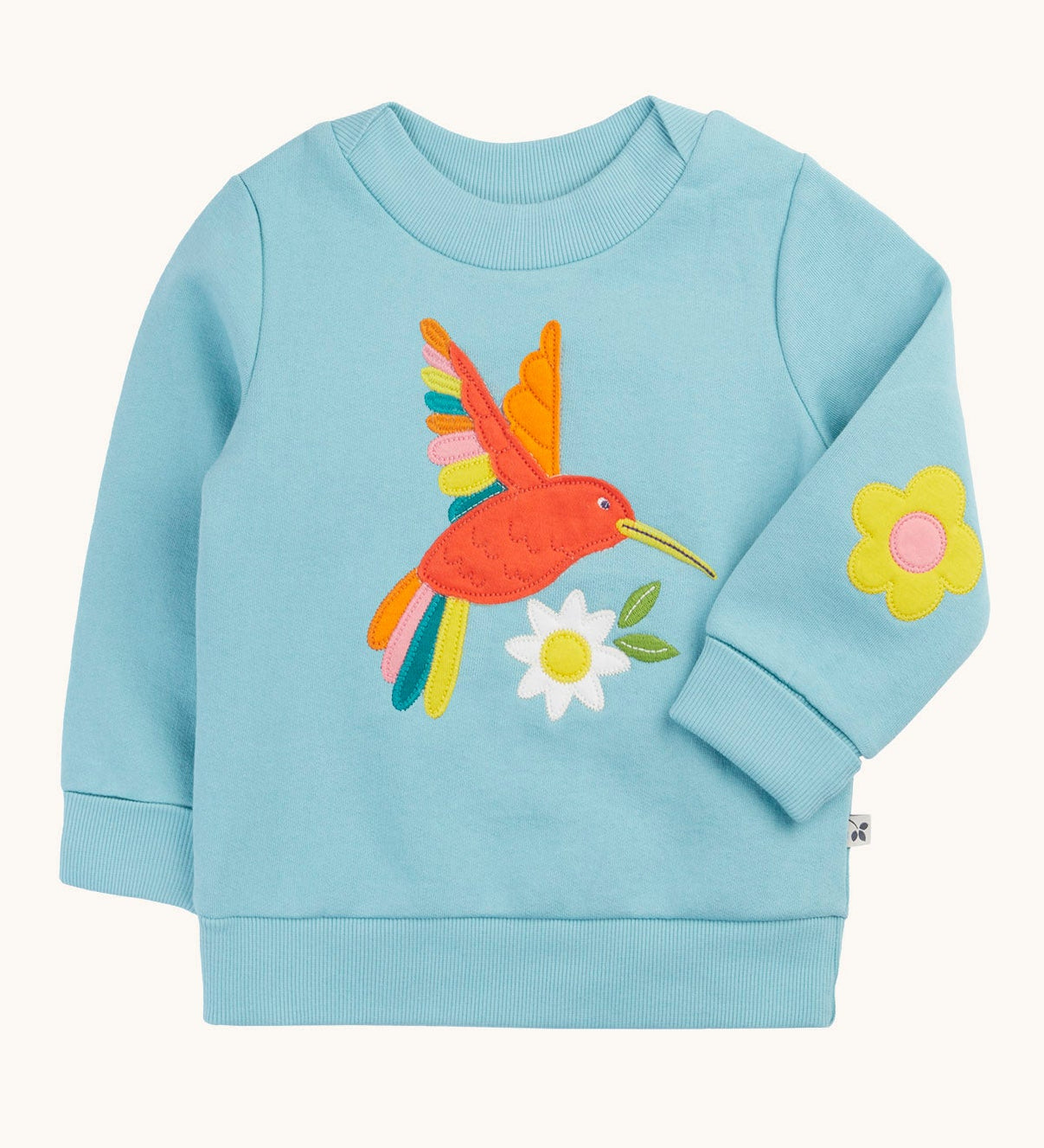 Frugi organic cotton jumper laid flat. In light blue with a red playful hummingbird design on the front and a yellow flower patch on the sleeve.