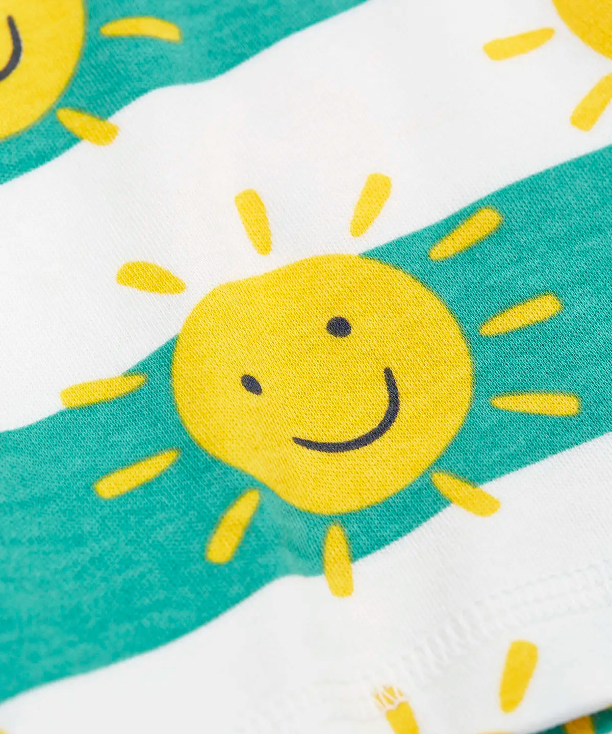 Frugi green and white striped short laid flat showing the repeating yellow smiling sun design
