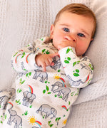 Baby wearing Frugi's white kimono style zipped babygrow with repeating elephant prints