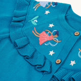 A closer look at the beautiful embroidered fairies on the Frugi Romi Ruffle Cardigan - Deep Water/Fairies. The image also shows the ruffled collar fabric, and stars surrounding the fairies.