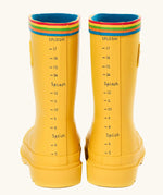 Back of the Frugi natural rubber, waterproof puddle buster wellingtons in yellow showing the rainbow strip on the top and a fun splash meter 