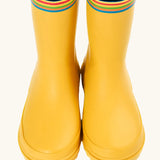Front of the Frugi natural rubber, waterproof puddle buster wellingtons in yellow showing the rainbow strip on the top and blue inner lining