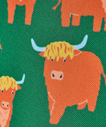 Frugi explorers backpack in green with showing close up of the repeating highland cow design.