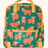 Frugi explorers backpack in green with a repeating highland cow design. Features a small front compartment and main compartment with yellow handle