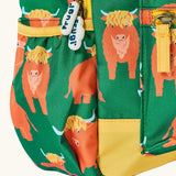 Side of Frugi explorers backpack in green with a repeating highland cow design showing the side pocket