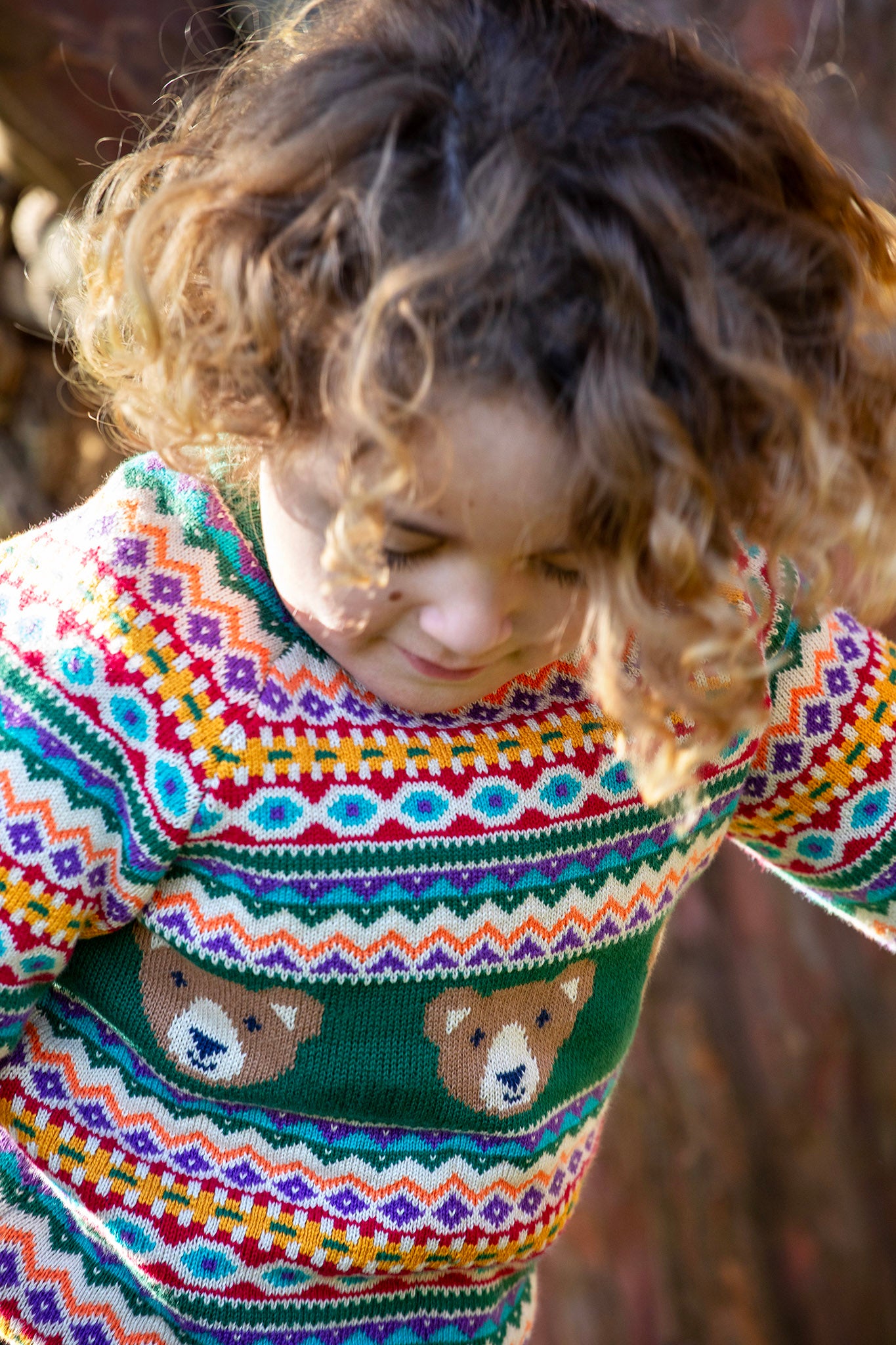 A close up of a child wearing the Frugi fowey fairisle bear knitted jumper showing the fairisle detail
