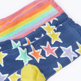 A close up of the blue with bold stars socks from the Frugi Frill Socks 2 Pack in stars available at Babipur. Sock features a gentle frill around the ankle and a yellow heel/toe panel