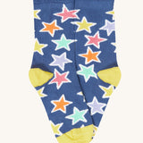 The blue with bold stars socks from the Frugi Frill Socks 2 Pack in stars available at Babipur. Sock features a gentle frill around the ankle and a yellow heel/toe panel