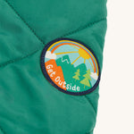 The Get Outside patch on sleeve of the Frugi Robin Reversible Quilted Jacket - Teal/Moon