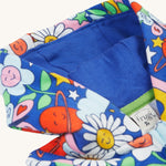The hood on the Frugi Snuggle Suit - Retro Happy, with a royal blue hood lining and the retro happy print on the outside 