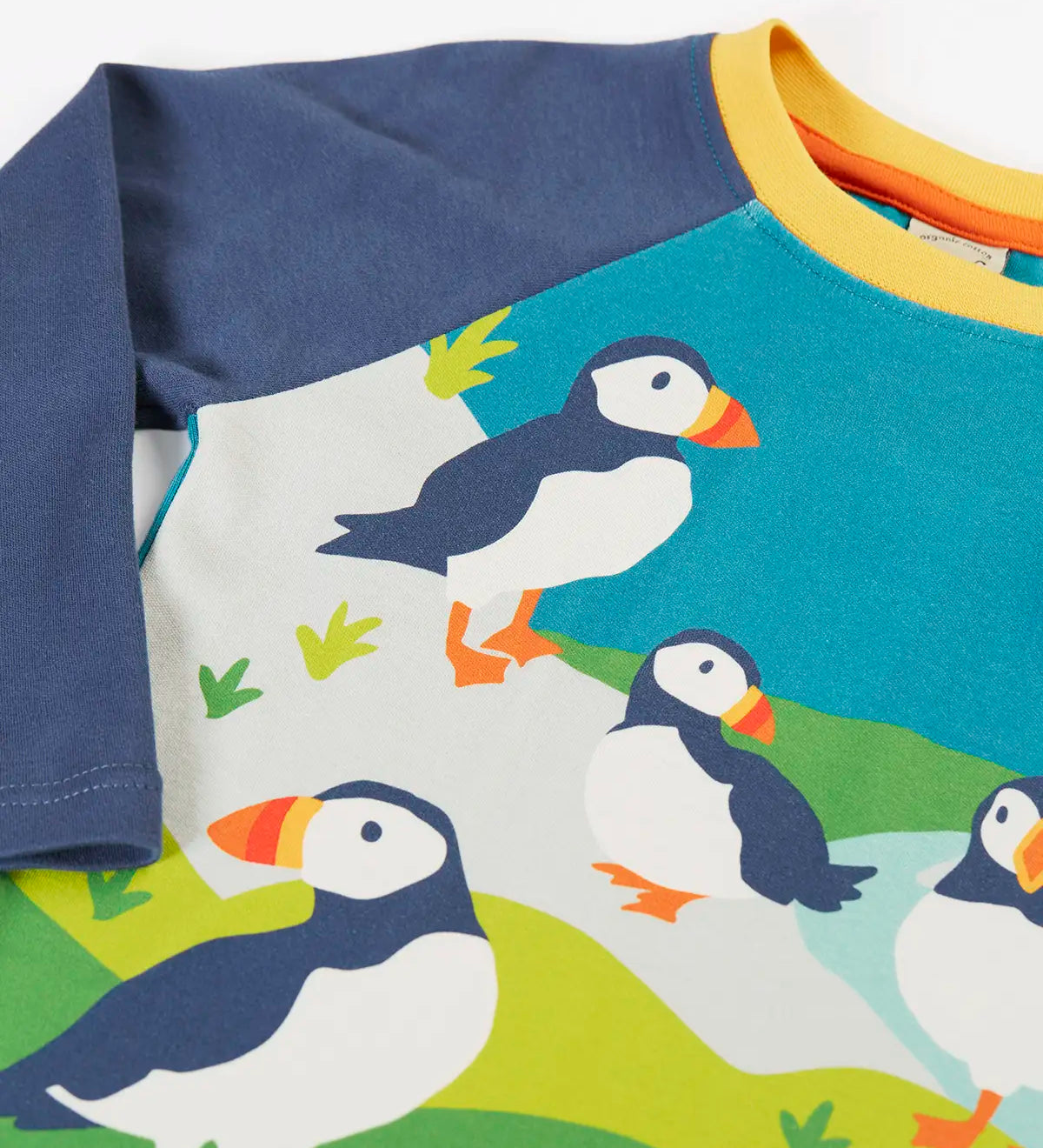 Frugi horizon raglan long sleeve organic cotton top laid flat showing close up of a playful puffin design on the front 