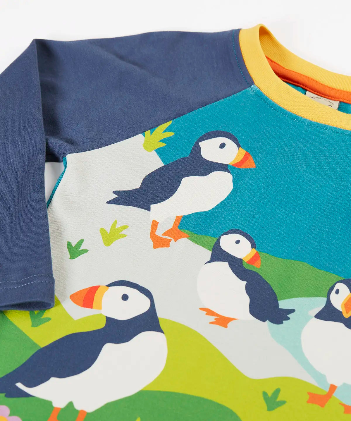 Frugi horizon raglan long sleeve organic cotton top laid flat showing close up of a playful puffin design on the front 