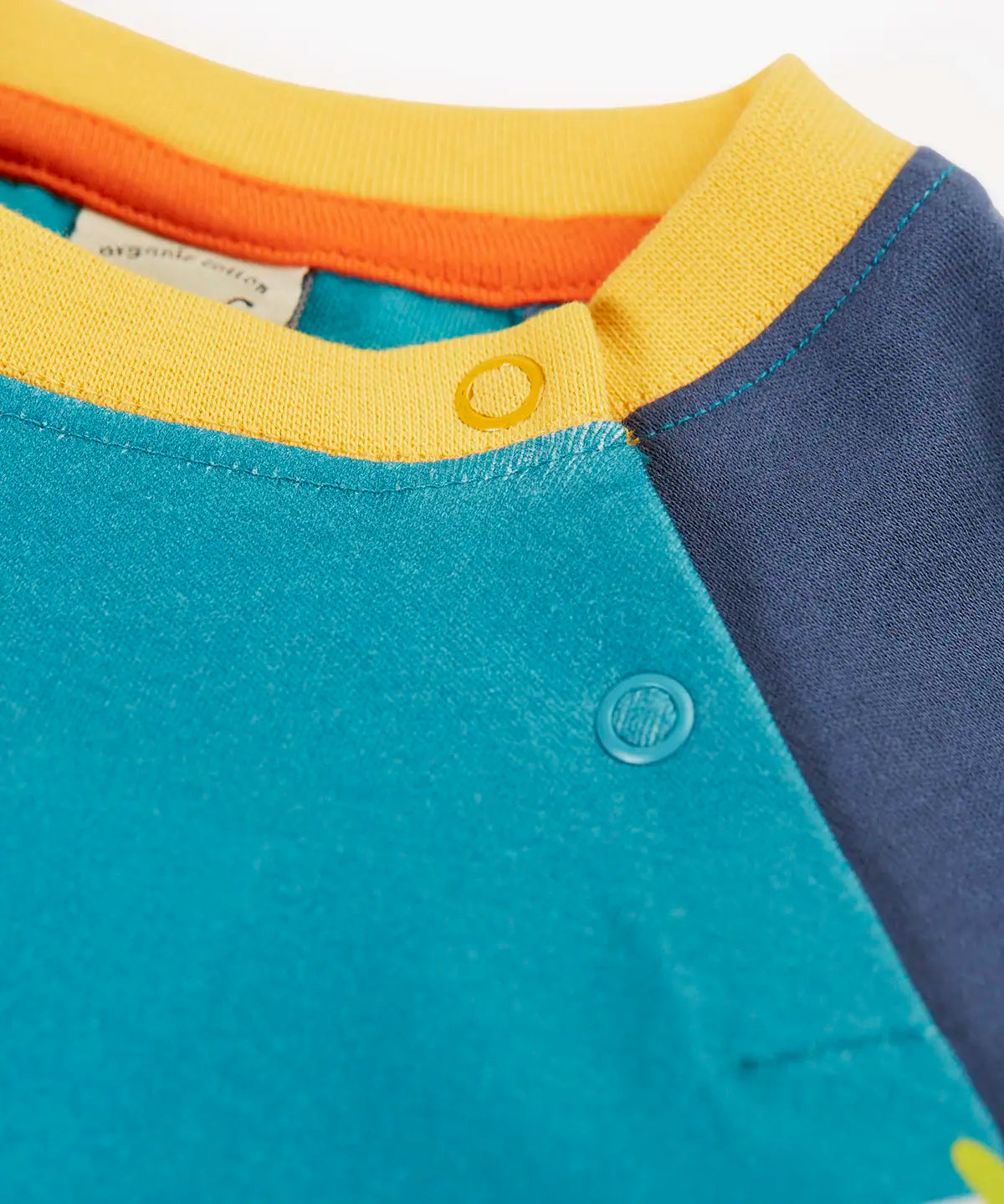 Frugi horizon raglan long sleeve organic cotton top laid flat showing close up of a popper fasteners on the shoulder for easy dressing