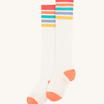 Frugi Hygge Rib Knee Socks - Soft White Rainbow. Knee length socks in white, with rainbow stripes at the top in red, orange, green, blue and yellow. With orange toes and heels