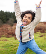 Girl wearing Frugi Juana Fleece jacket in cream with corduroy piping and pocket details in blue floral.