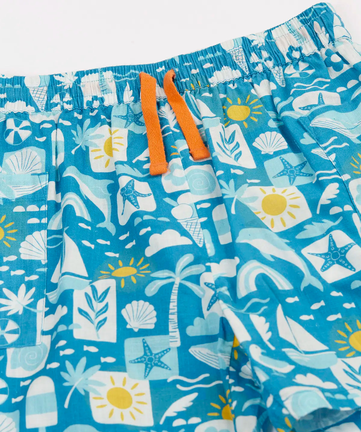 Frugi blue Kai shorts laid flat showing repeating beach inspired designs and orange waist cord