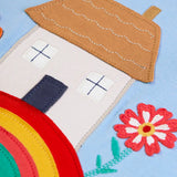 Frugi kids top showing close up of highland cottage house applique on light blue organic cotton fabric