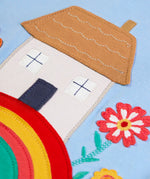 Frugi kids top showing close up of highland cottage house applique on light blue organic cotton fabric