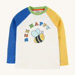 Frugi Tamar Raglan Top - Soft White/Bee Happy. A colourful, raglan top with one yellow and one blue sleeve, a green collar, a white body with a cute bee print and the words "Bee Happy" printed above