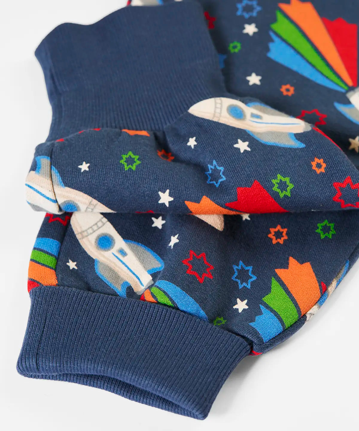 Frugi's GOTS organic cotton big hooded snuggle suit in navy with repeating flying rocket prints showing close up of the turned up leg cuffs